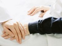 Medical doctor holding patient's hands and comforting her with care, Doctor supports her palliative patient with sympathy. (Selective Focus)