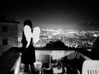 Naples February 2008.
A girl looking out onto the terrace of a house during a carnival party.